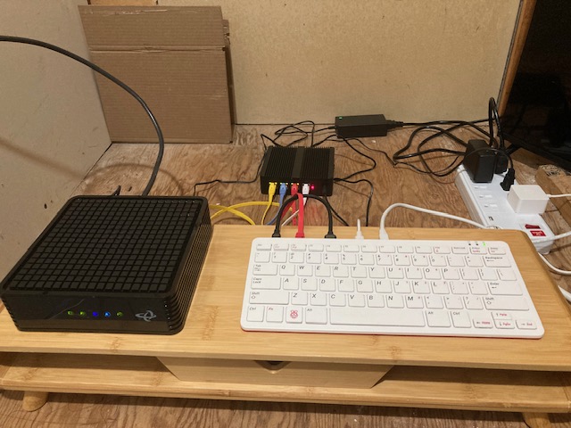 Photo of my network setup.
Shows a modem plugged into a small OpenBSD router, and a Raspberry Pi 400
plugged into that router via ethernet